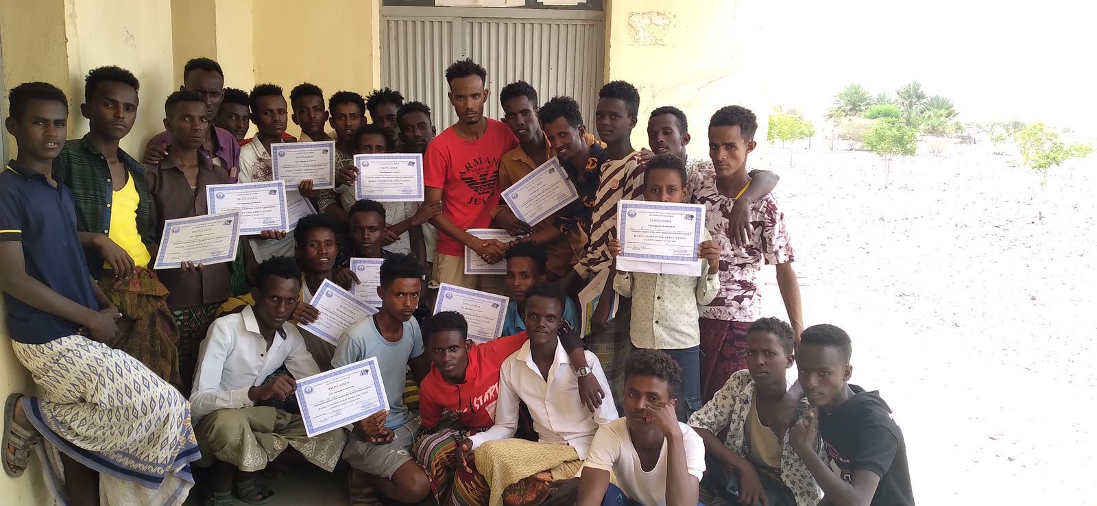 Graduates of an African Vision Basic Computer Application course holding their diplomas
