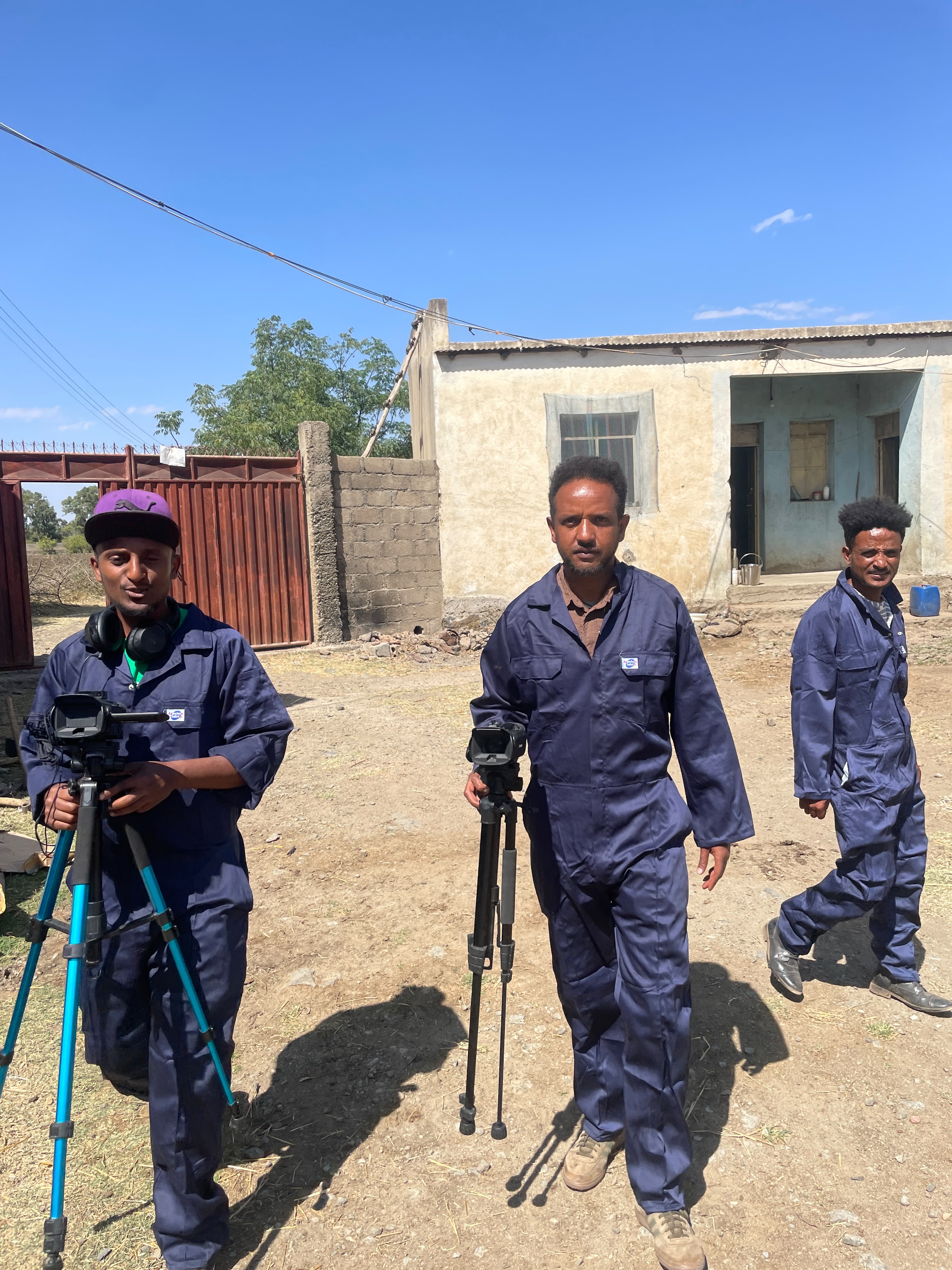 African Vision production crew on location with cameras and tripods for a field documentary shoot